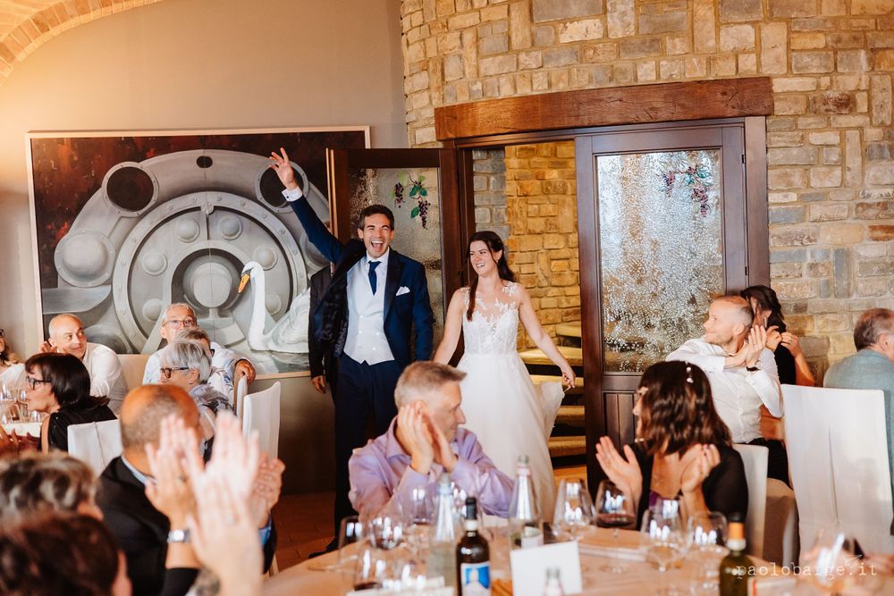 Wedding reception guests celebrate in a rustic stone venue during dinner.