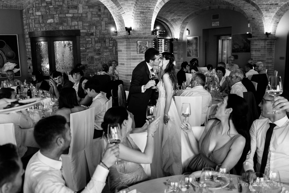 Black and white photo of wedding reception celebration in an elegant stone arch venue.