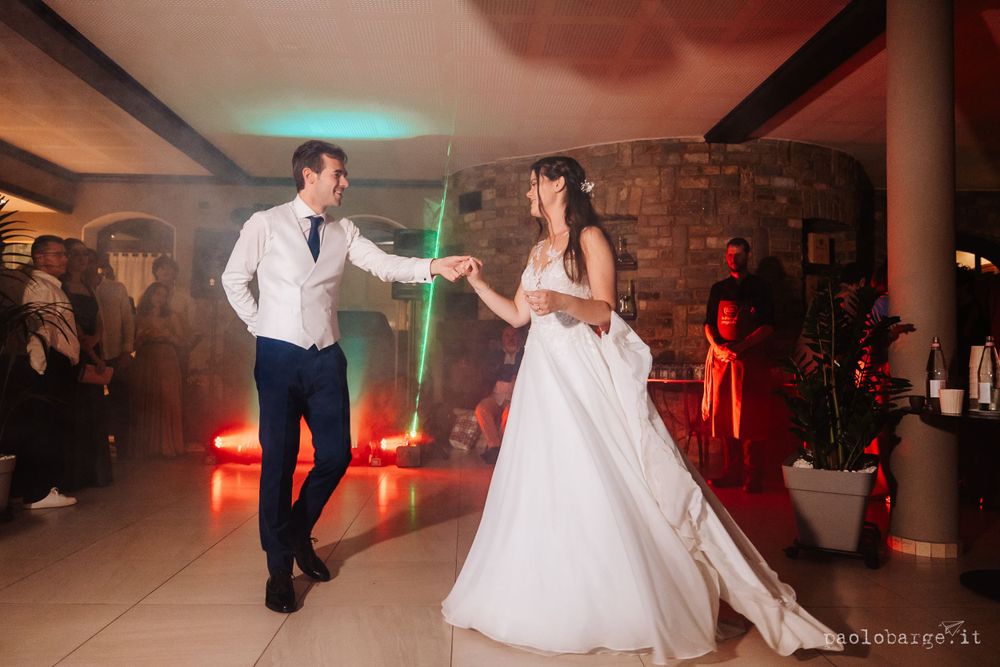 Couple dancing with glowing lightsabers at their wedding reception with colorful lighting effects.