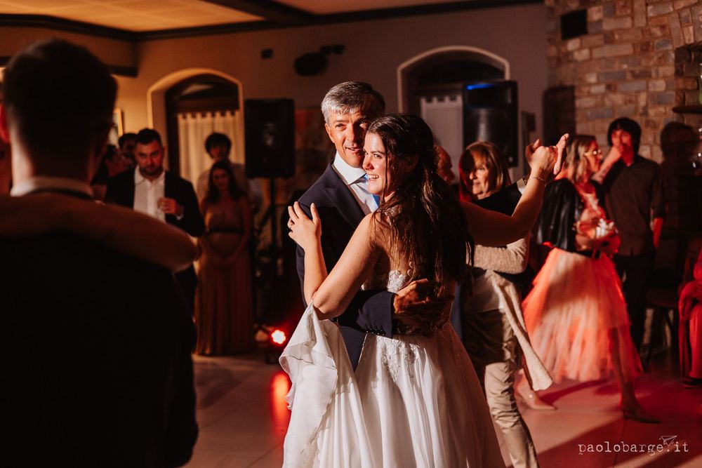 Wedding party celebrates at the bar with enthusiastic expressions and raised hands.