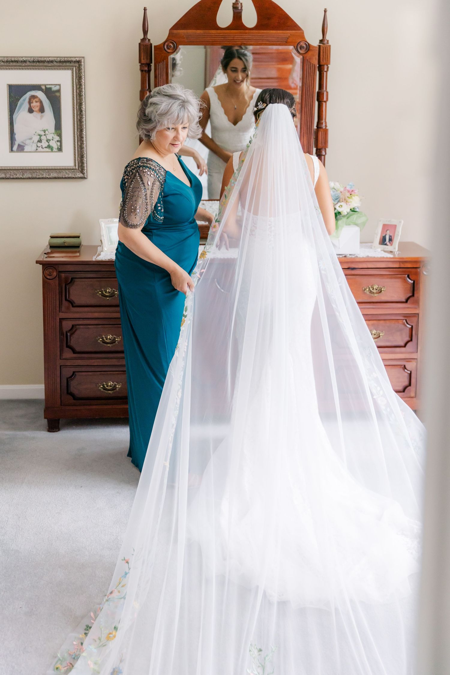 Elegant wedding preparation scene with flowing veil and antique wooden dresser.