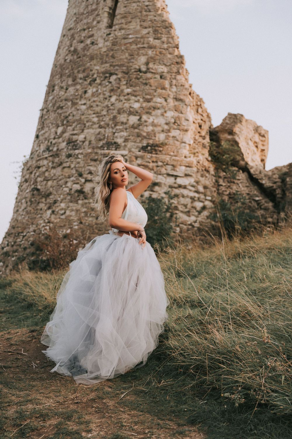 Beautiful white female dressed in blue and purple hue dress Hadleigh Castle in background