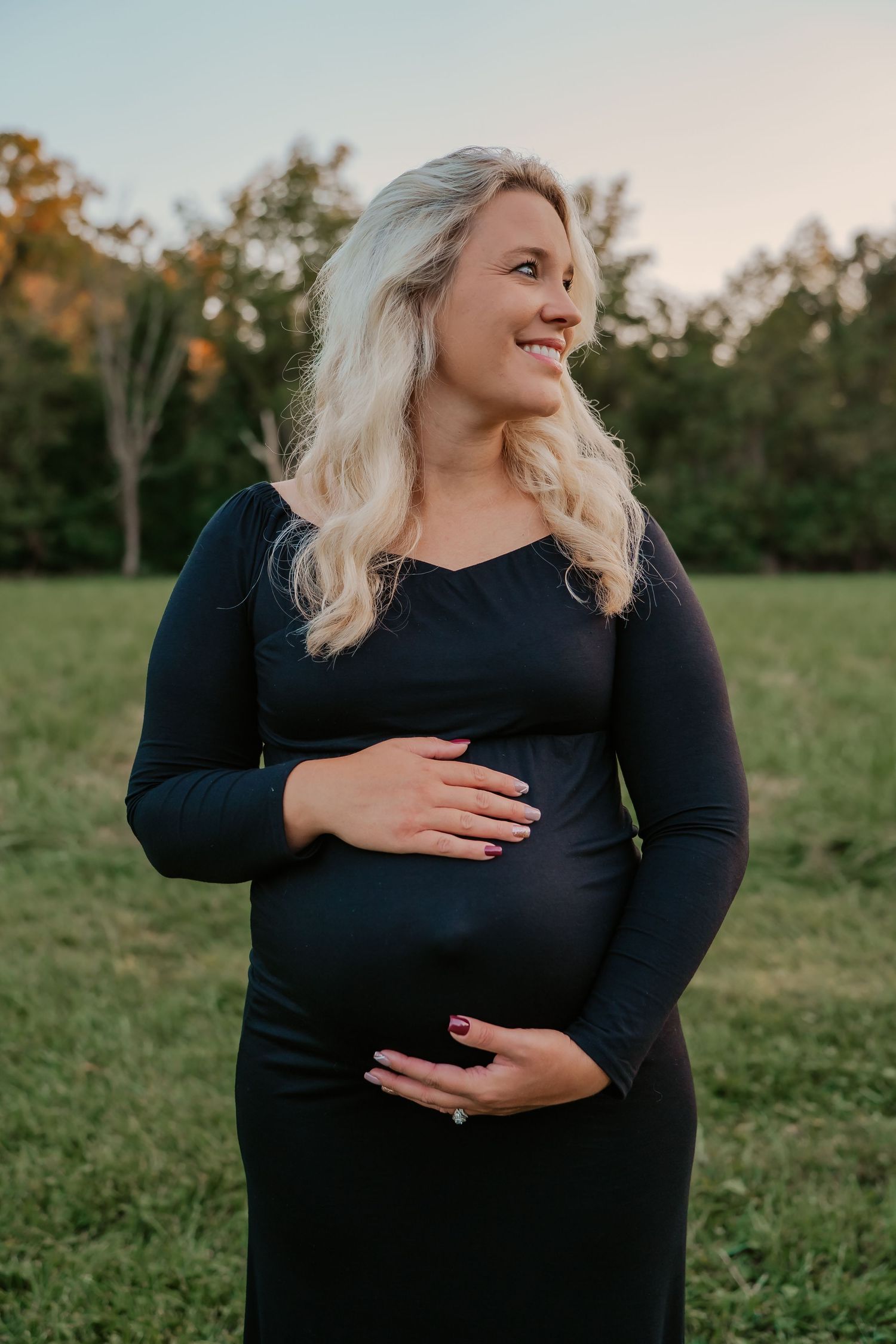 glowing pregnancy mother in fields with true to color tones at golden hour for maternity photography session in Cincinnati Ohio.