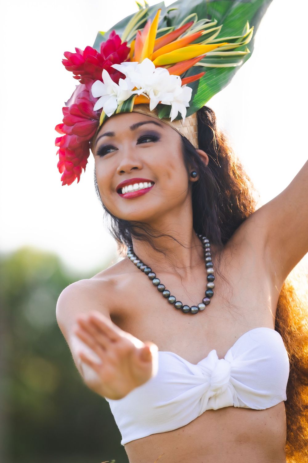 Dancer in traditional Hawaiian costume with tropical flower headdress.