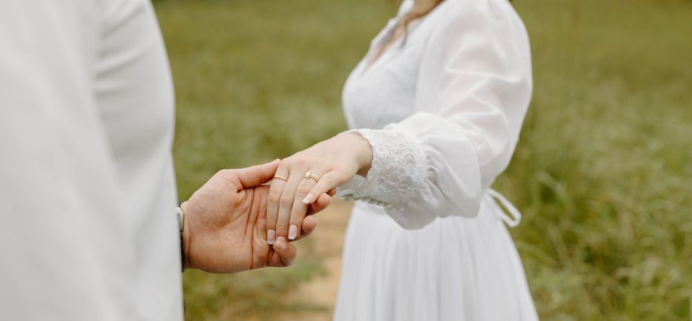 Close-up of hands holding during an outdoor wedding ceremony.
