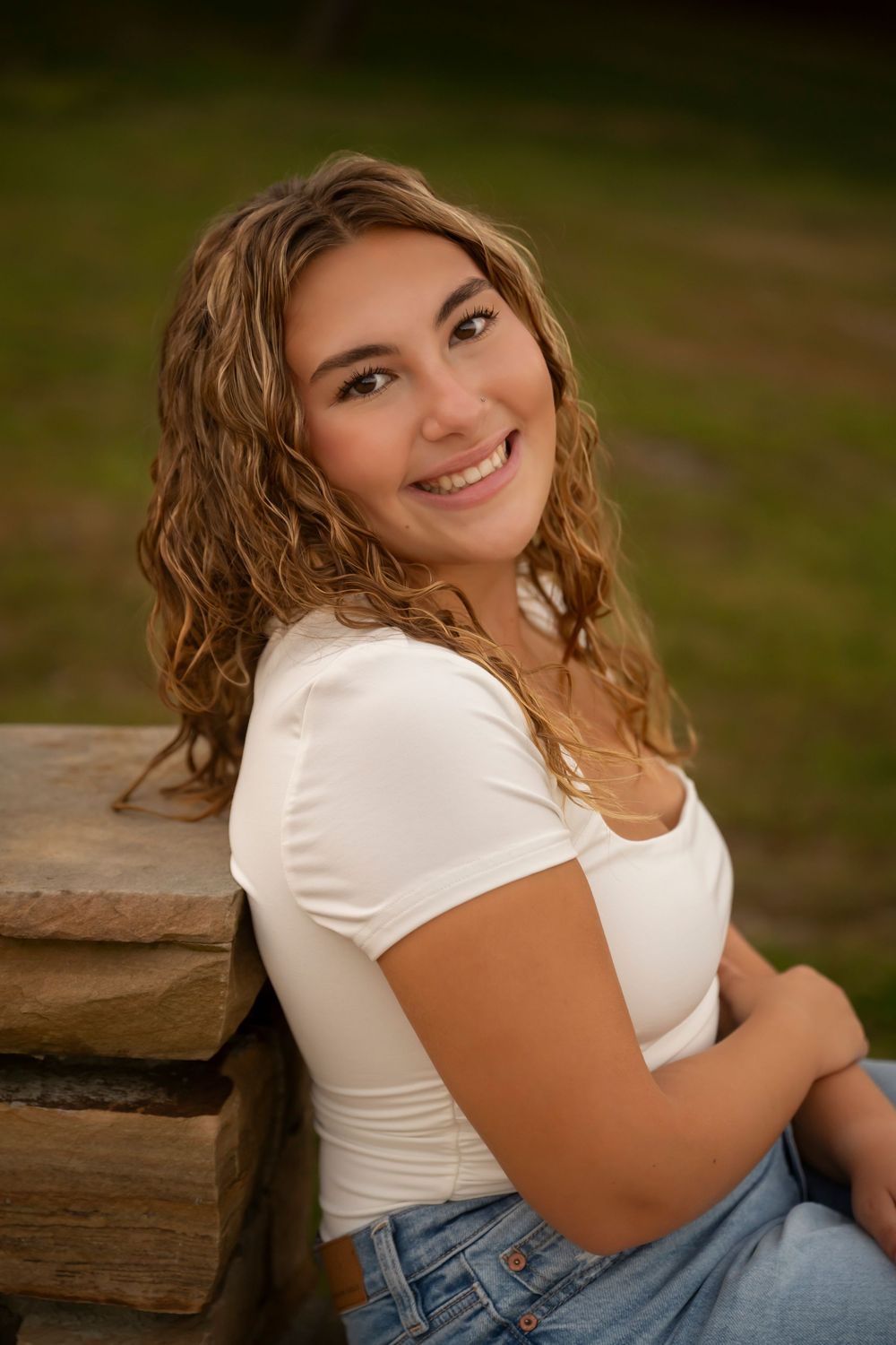 A series of outdoor portrait photos showing someone in a white top and jeans sitting on rustic wooden steps.