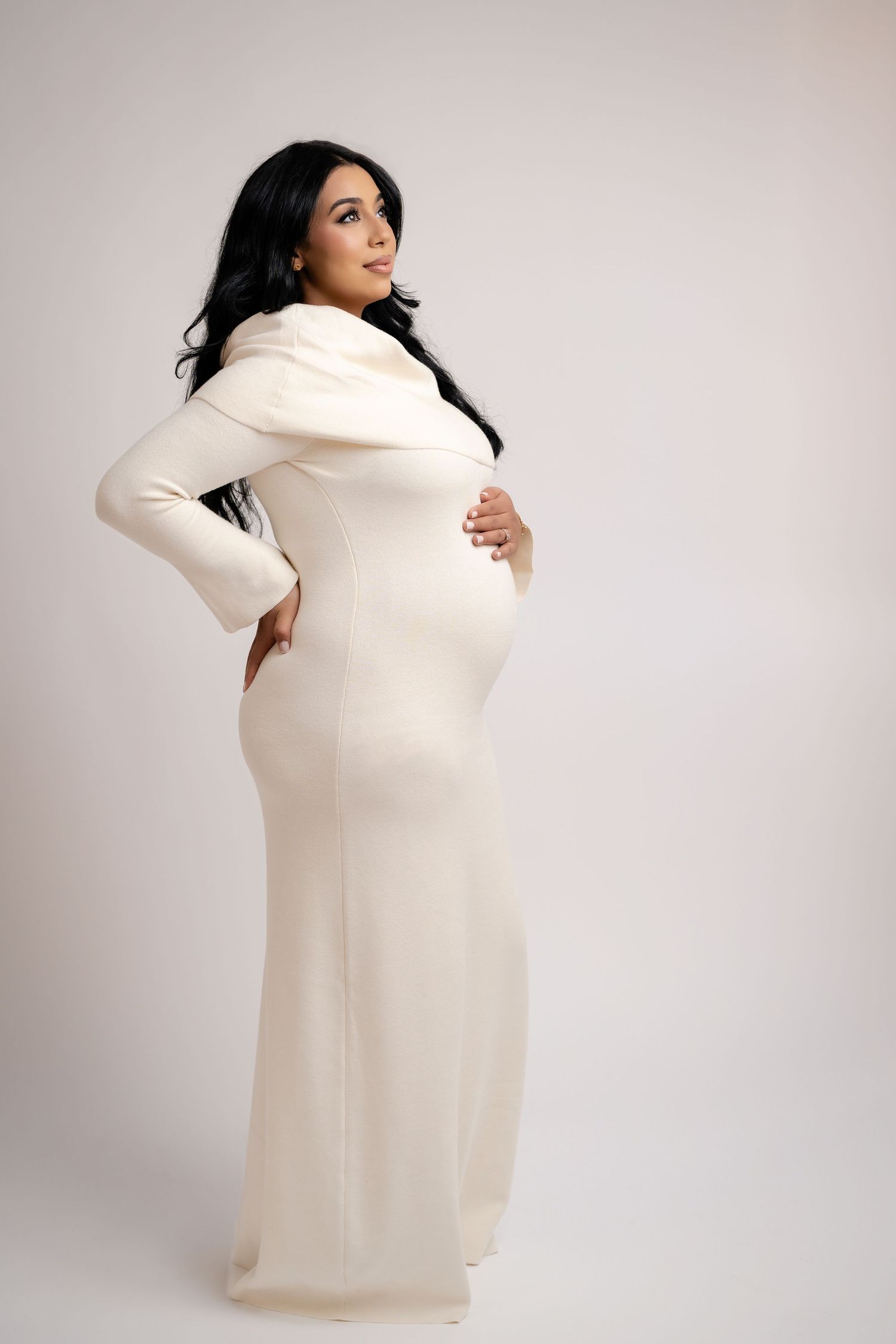 Fashion portrait series in cream turtleneck sweater against light background.