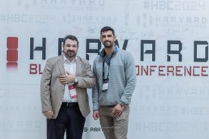 Professional conference setup with a large banner displaying 'Harvard Blockchain Conference' text.
