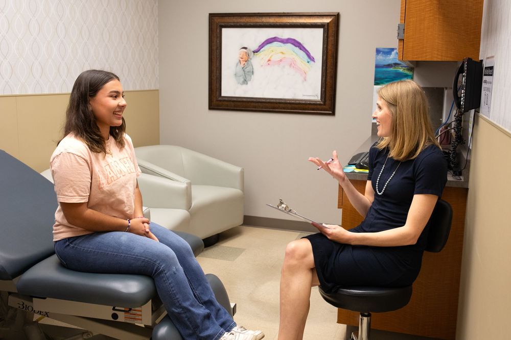 Candid image of a female patient and gynecologist having a conversation in an exam room