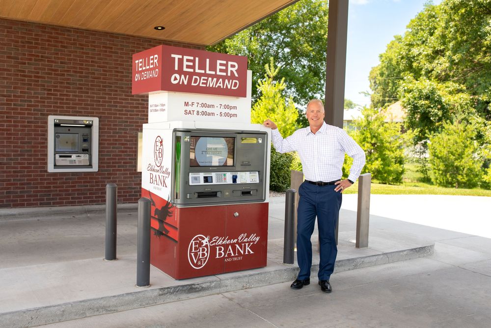 Business branding image taken by Truly Juli Photography of a bank manager standing next to a new virtual bank teller machine in Norfolk