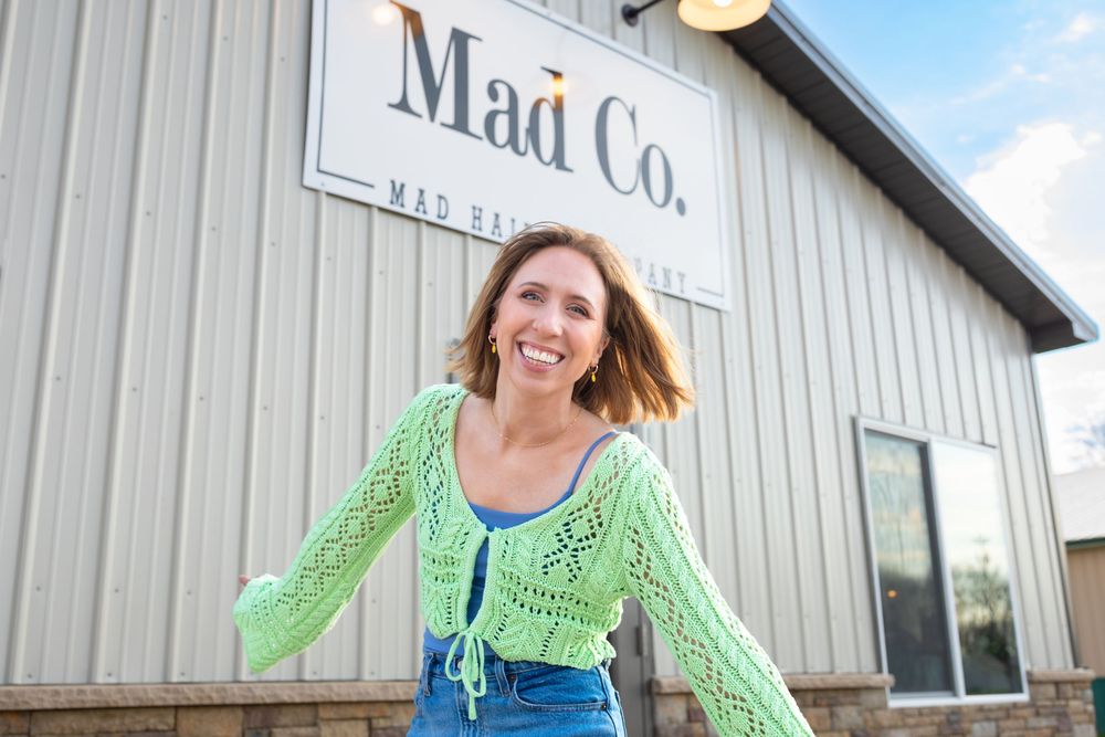 Business branding photo of a hair stylist standing next to her new store front in Dakota City