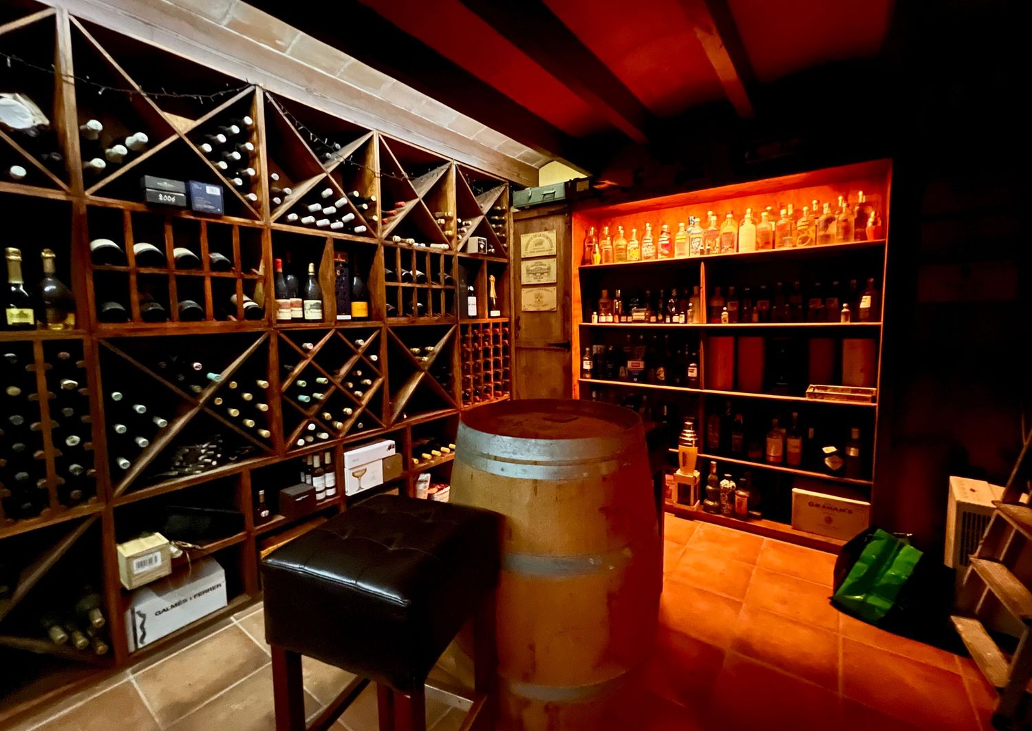 Modern cellar space with wood beams and illuminated wine rack storage displays glowing in warm lighting.