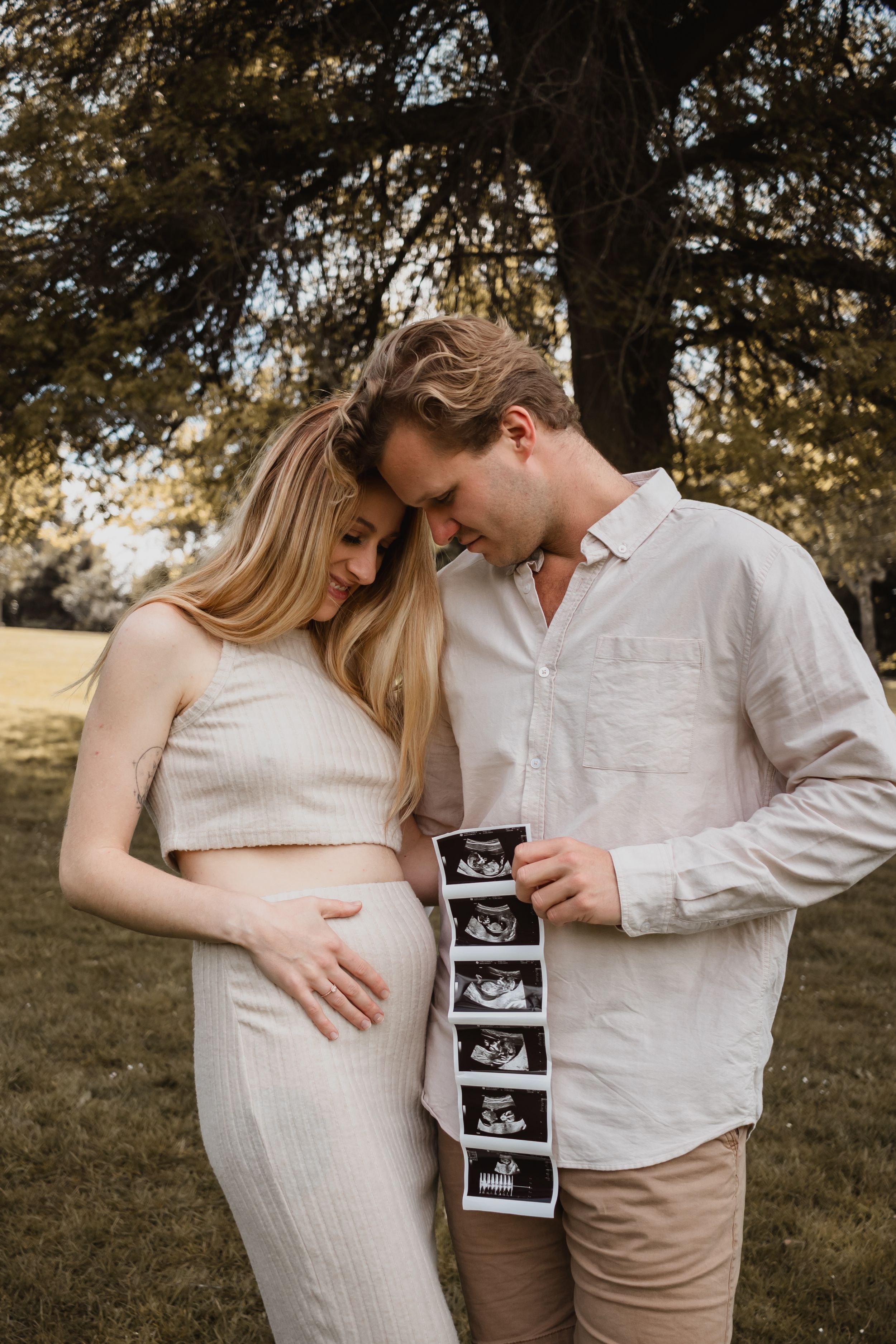 A couple holding photos of an ultrasound.