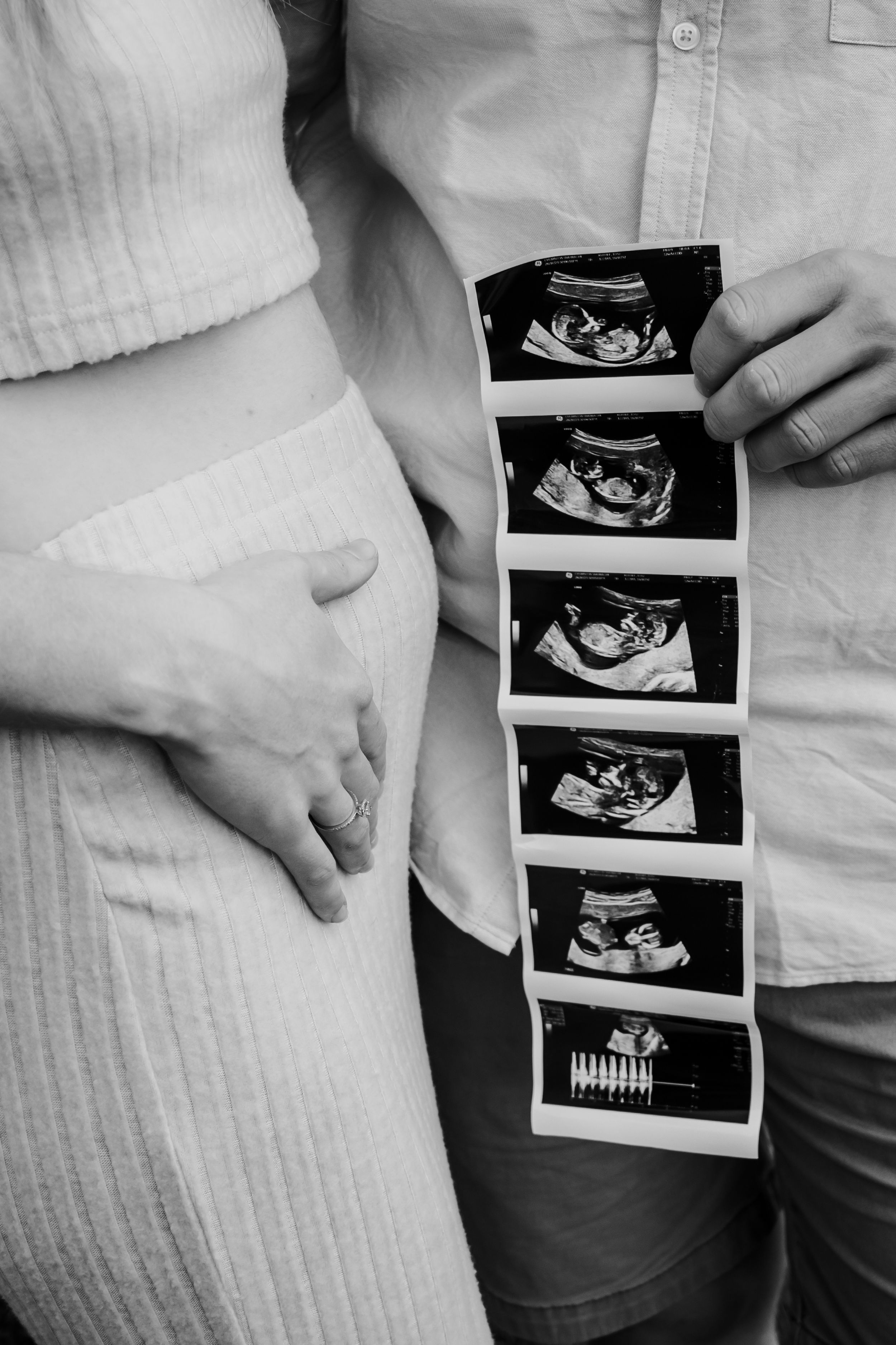 Close up of a couple holding photos of an ultrasound.