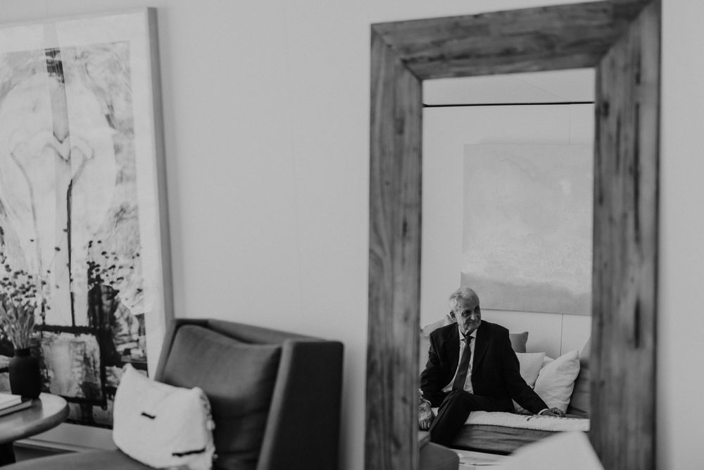 Black and white interior photo of office space with large framed mirror and artwork.
