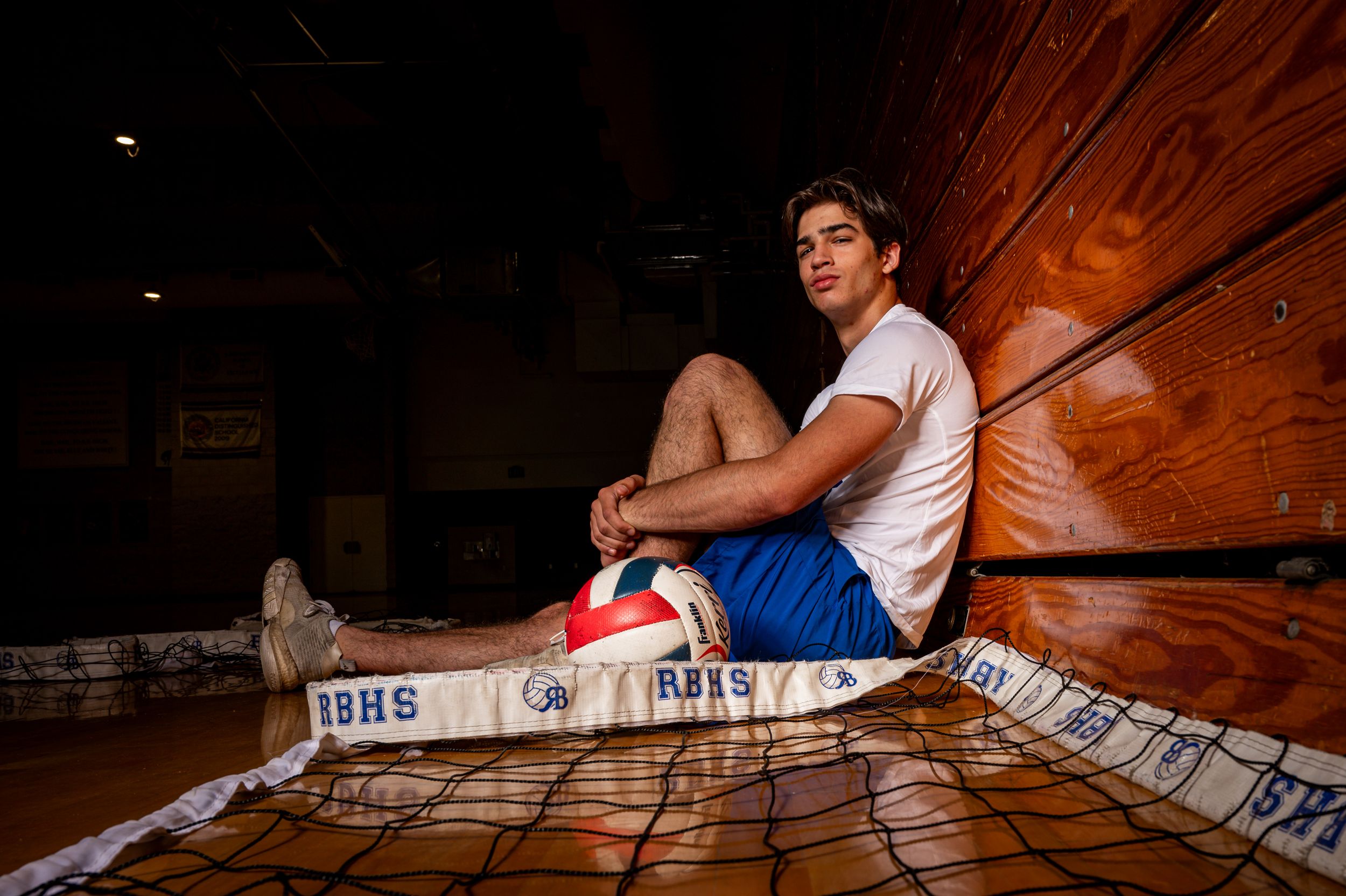 Volleyball player posing against bleachers.