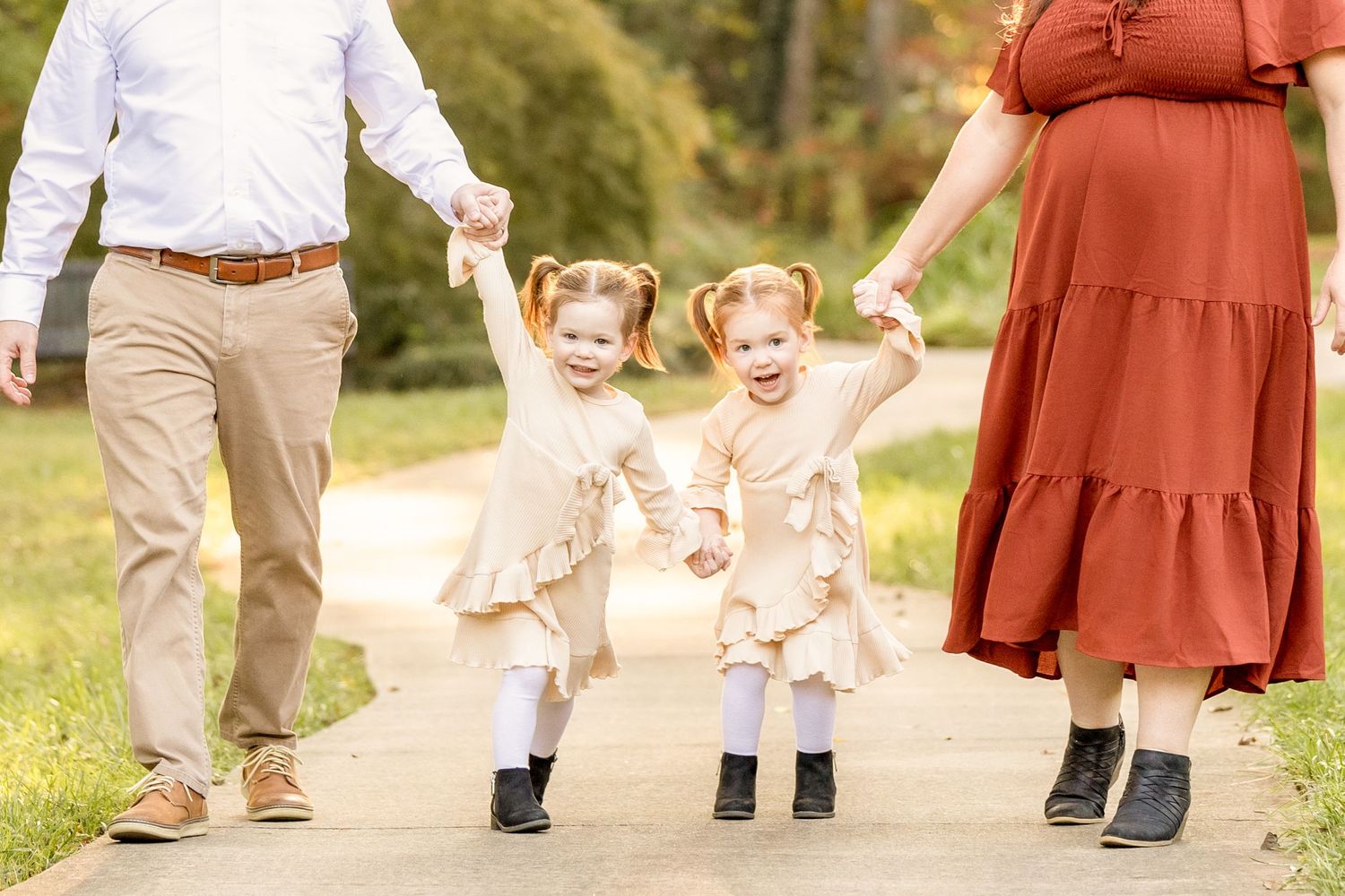 Family walking together on path while little ones jump with excitement.