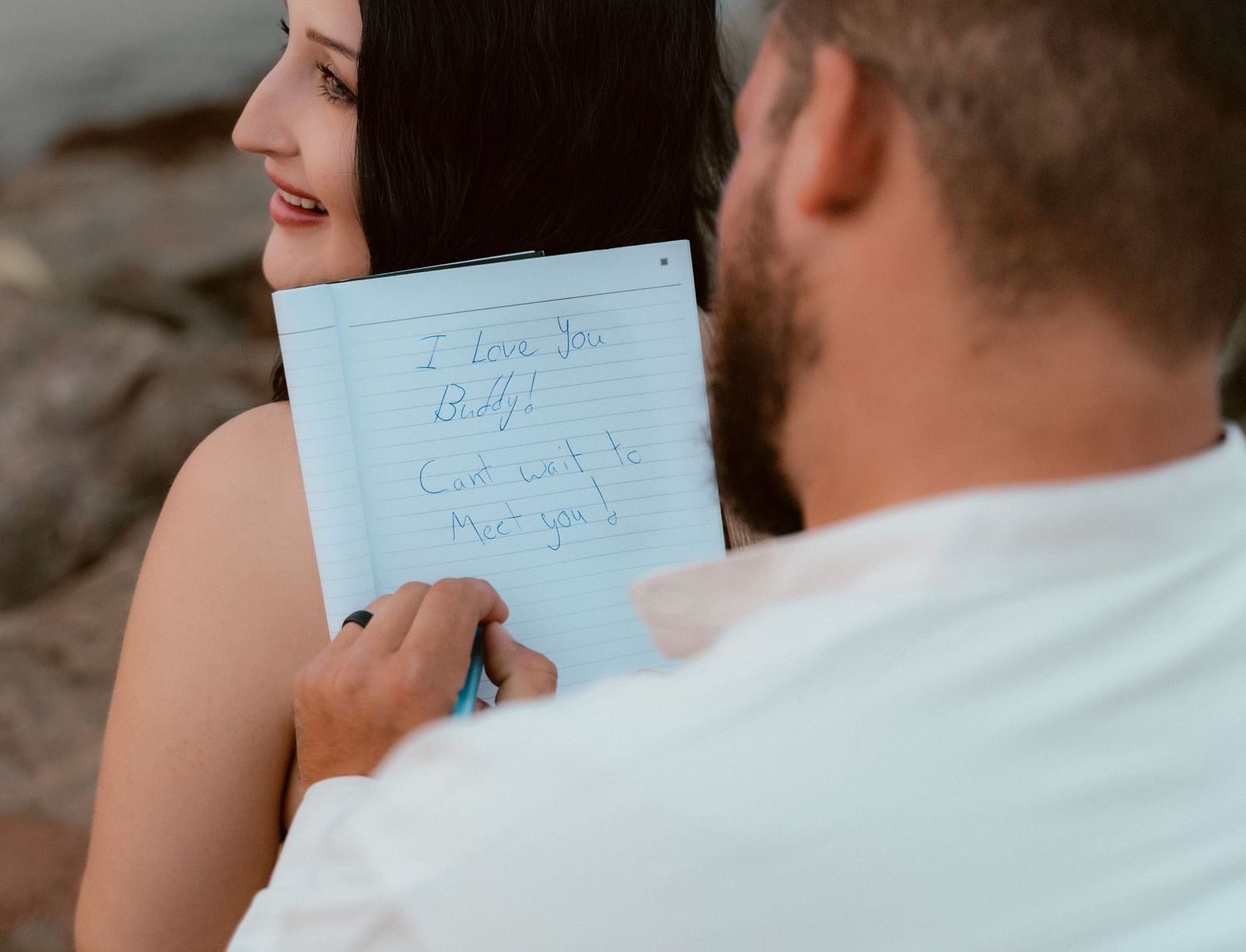 A close-up shot of hands holding a blue notebook with handwritten notes.