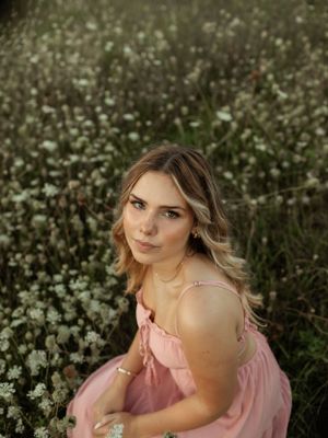 A dreamy portrait in a wildflower meadow featuring a pink dress and soft natural lighting.