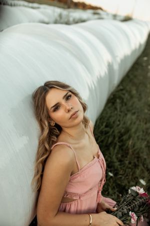 Artistic portrait against a white bale background showcasing a pink summer dress.