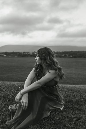 Black and white portrait overlooking rolling hills in a flowing dress.
