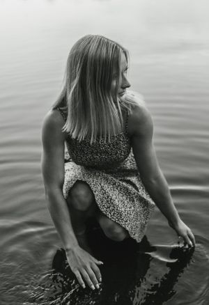 Black and white artistic shot by the water in a patterned summer dress.