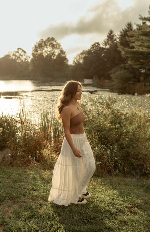 Golden hour portrait in nature wearing a white maxi skirt and brown crop top.
