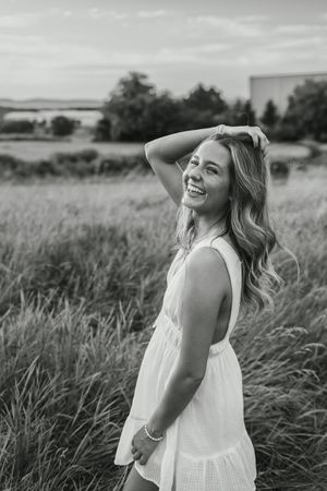 A series of black and white portraits showing joyful moments in a grassy outdoor field.