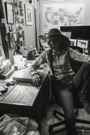 Black and white vintage photographs show a person wearing a western-style hat at a desk looking over paperwork.