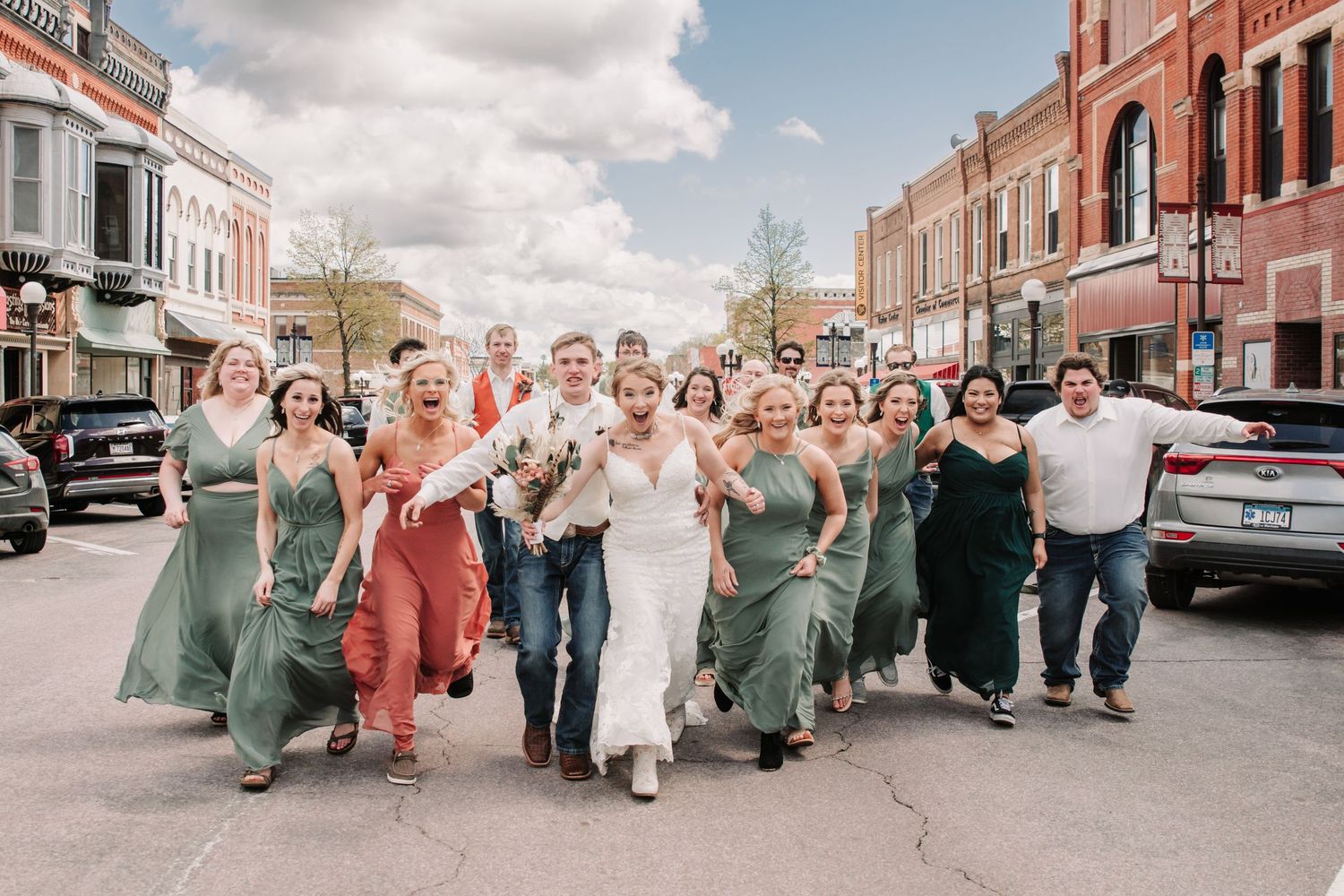 Wedding party poses along a charming brick-lined historic downtown street.