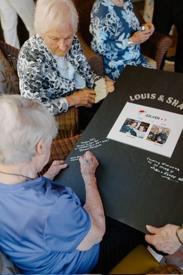 Person in blue writing in a guest book at a special event.