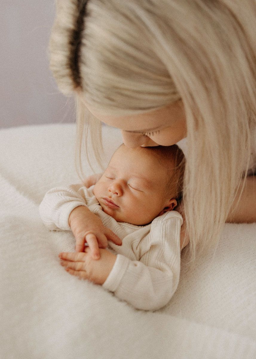 Artistic photo series capturing tender moments with a sleeping baby in cream tones.