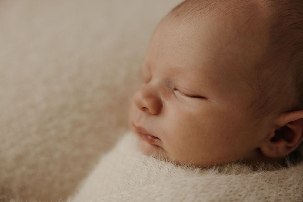 Close-up portrait series showing a peaceful sleeping newborn baby.