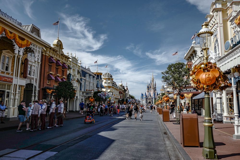 Main Street USA at Disney World features Victorian architecture and decorative lampposts under blue skies.