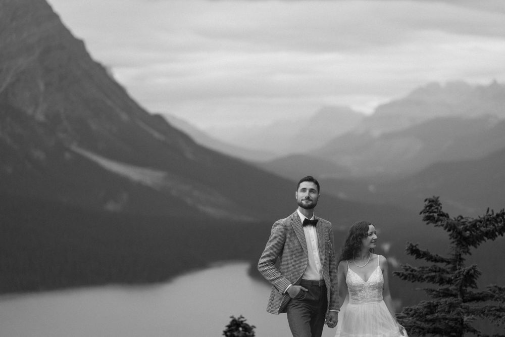 Dramatic mountain landscape with a lake nestled between snow-capped peaks in muted tones.