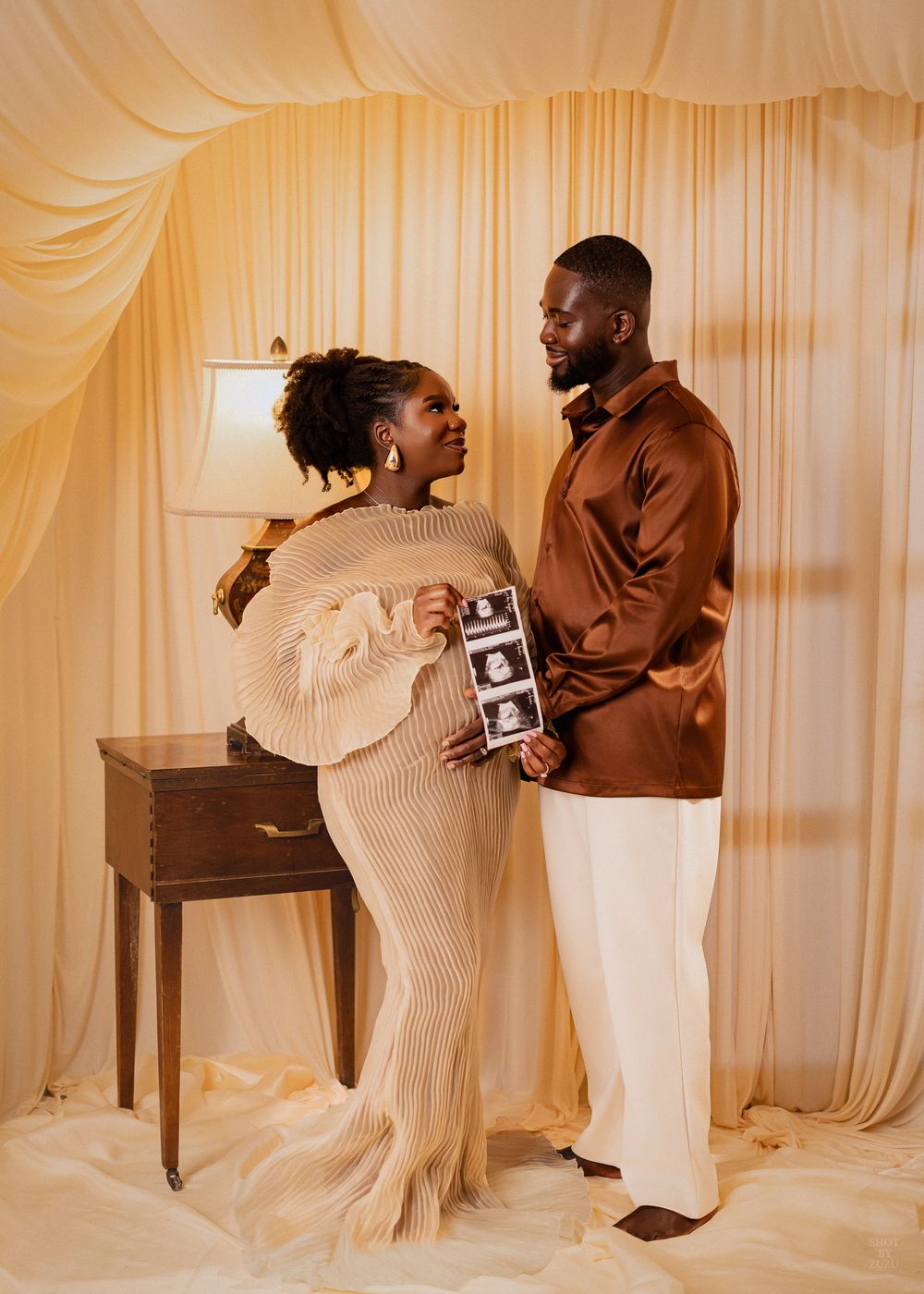 A series of romantic maternity photos showing an expecting couple in cream and brown outfits against a light curtain backdrop.