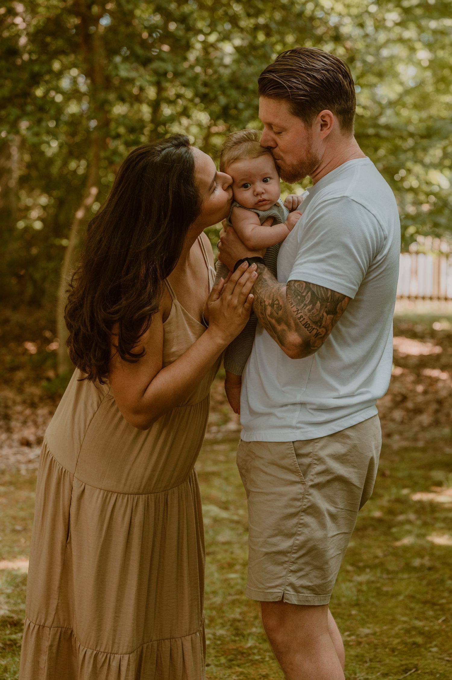 A family shares a tender moment together in a sunlit garden setting on a warm summer afternoon photo by Samantha Campbell imagery