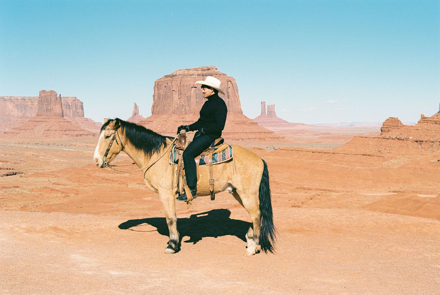Desert landscape with iconic Monument Valley rock formations in the background.