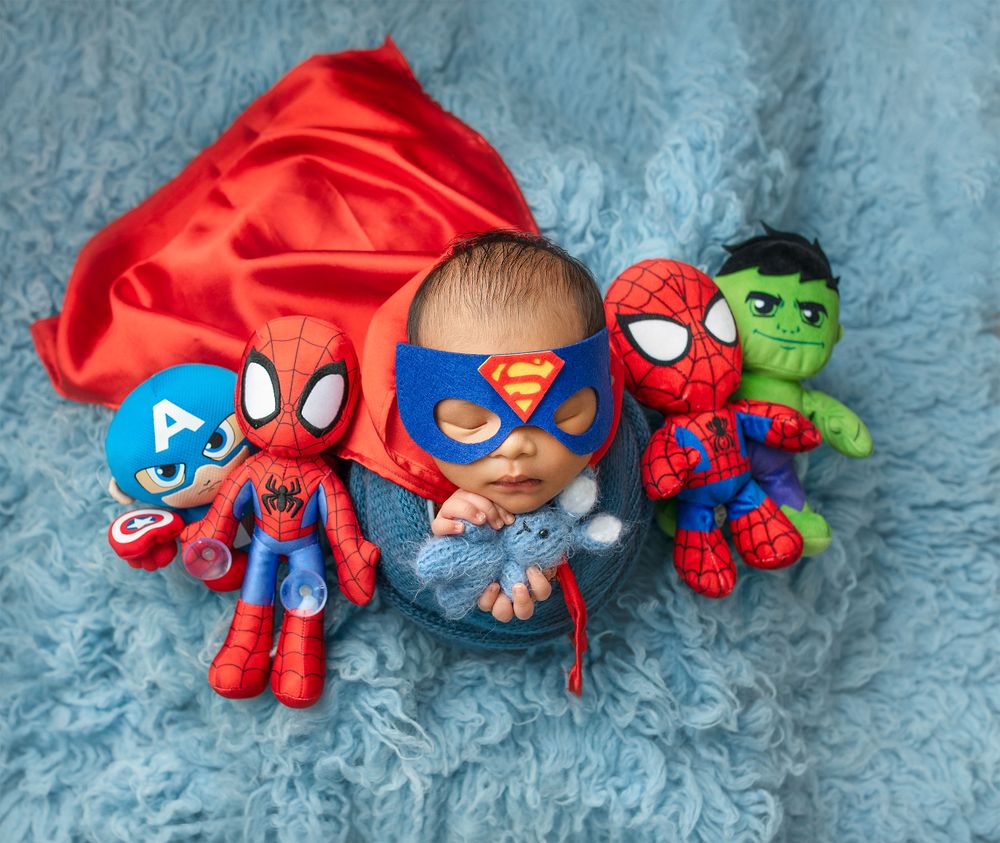 Collection of superhero plush toys including Spider-Man, Captain America and Hulk on blue textured background.