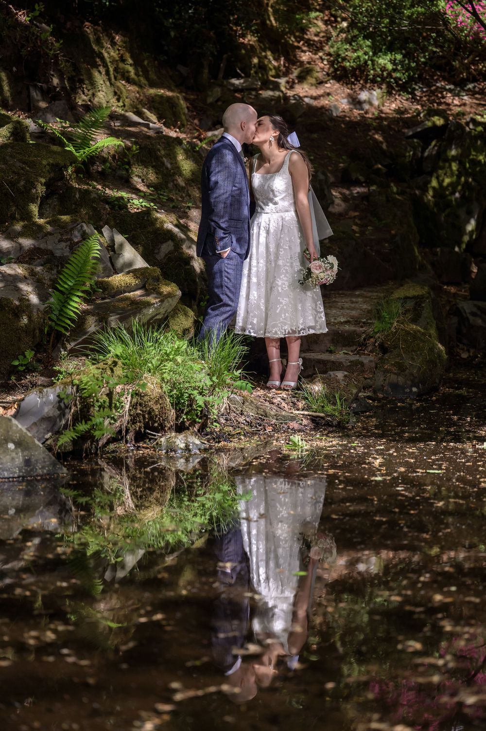 Bride and groom reflected in pool at Cragwood Country House Hotel