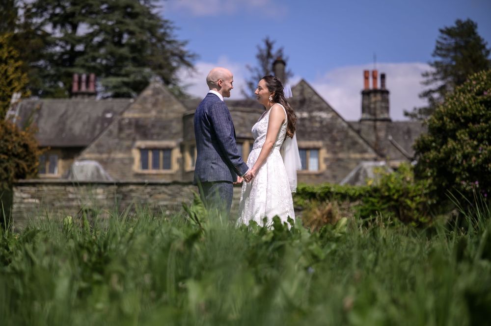 Bride and groom in gardens at Cragwood Country House with House in background