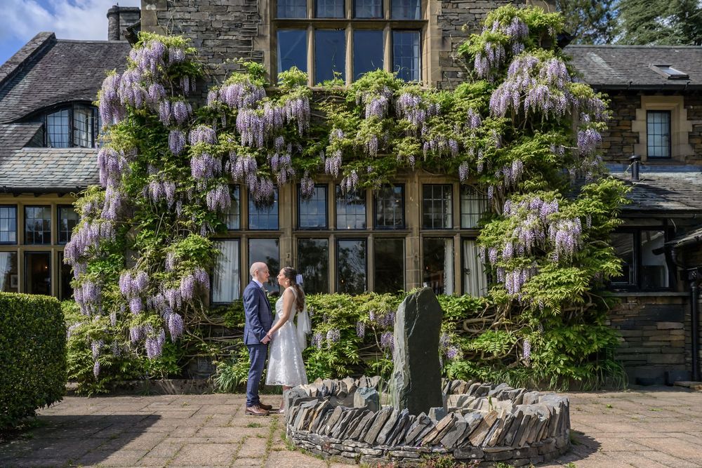Bride and groom portrait with wisteria and fountain at Cragwood Country House Hotel