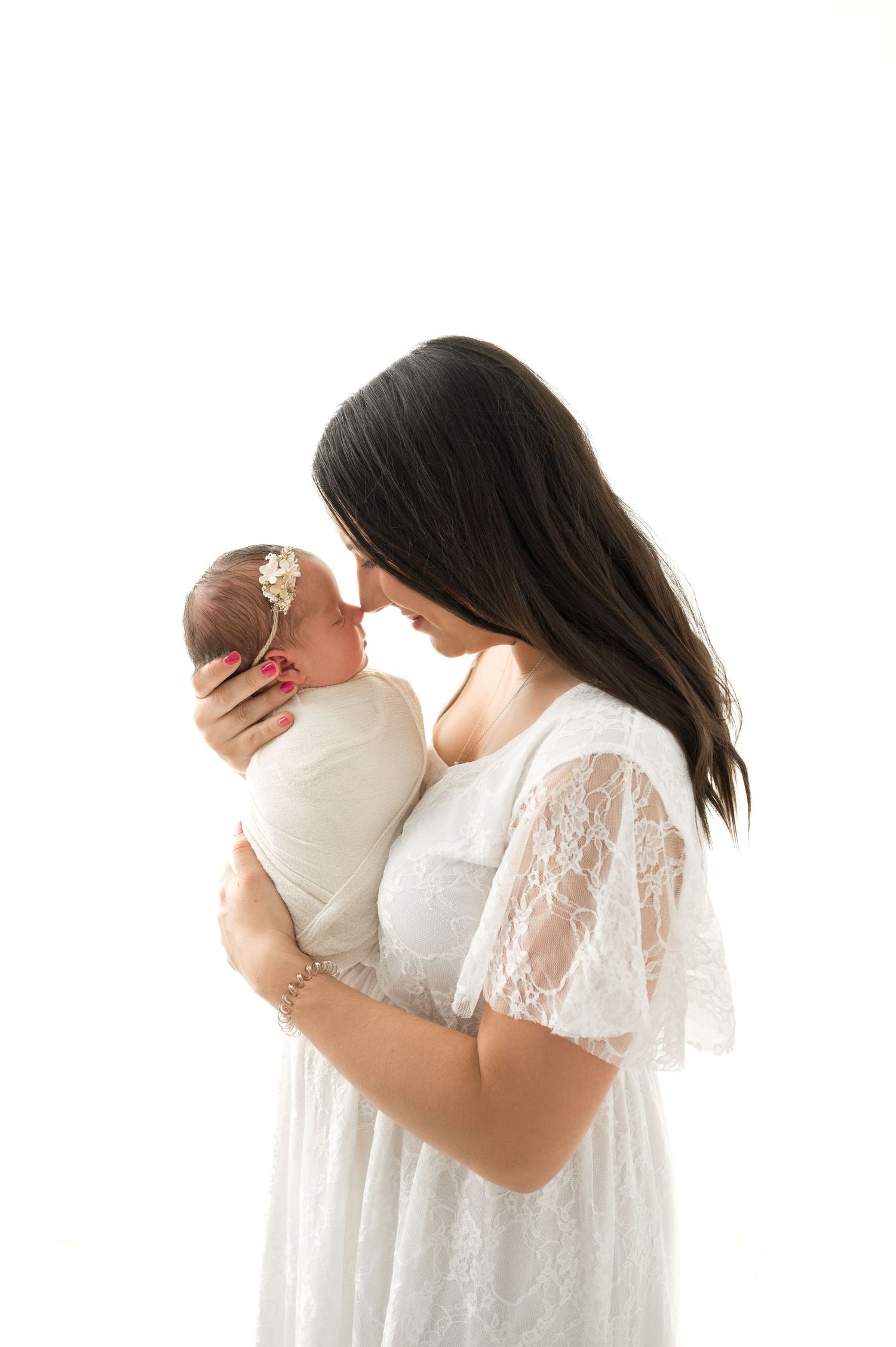 mother holding her baby in her arms and smiling during the newborn session in Woodbury MN