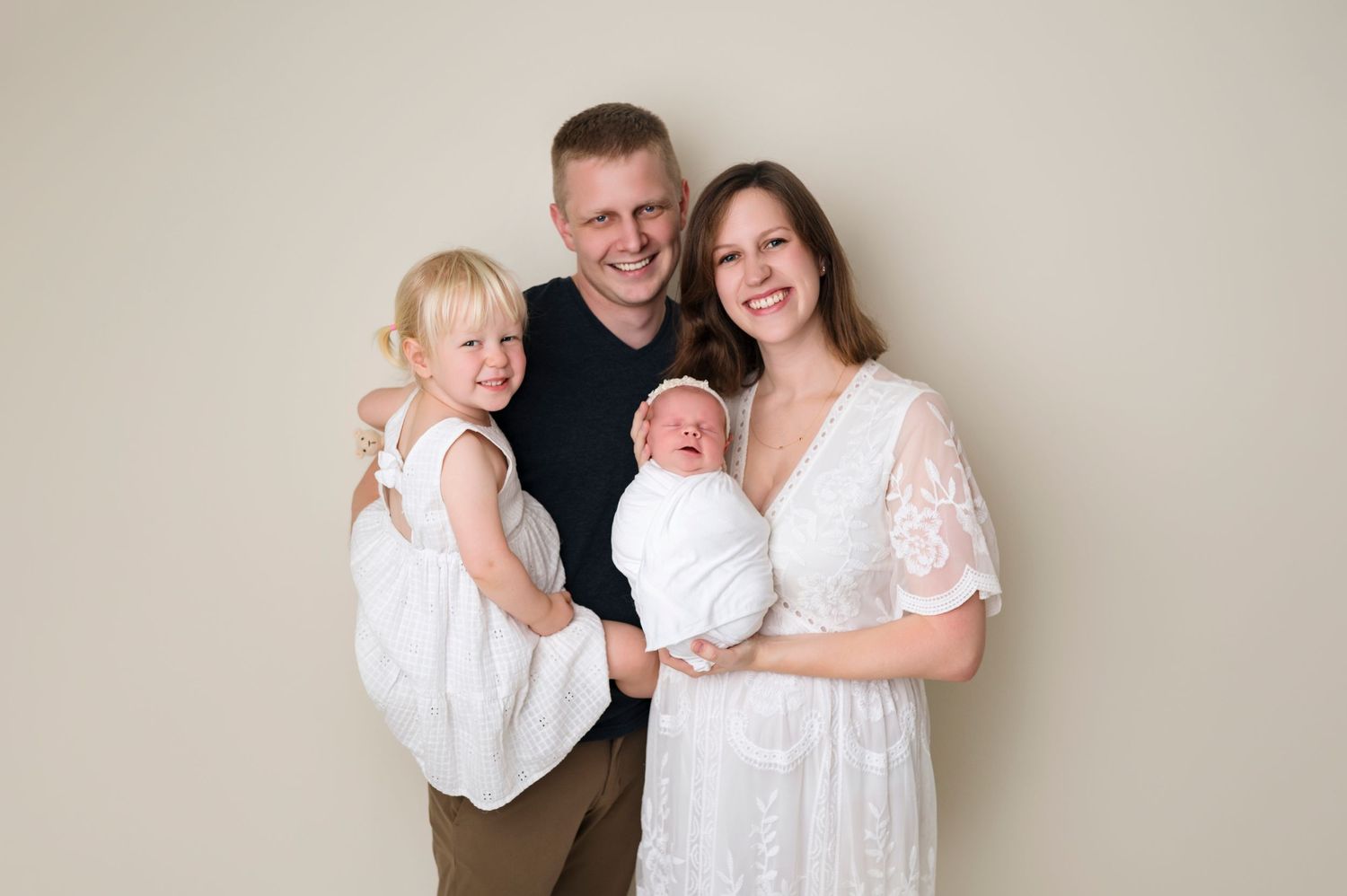 parents holding their baby in their arms and smiling during the newborn session in Woodbury MN