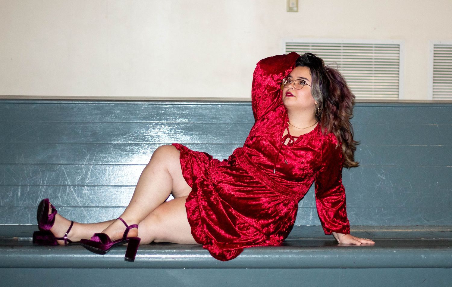 Woman in a red velvet dress and purple heels posing confidently on steps during a Chattanooga portrait session