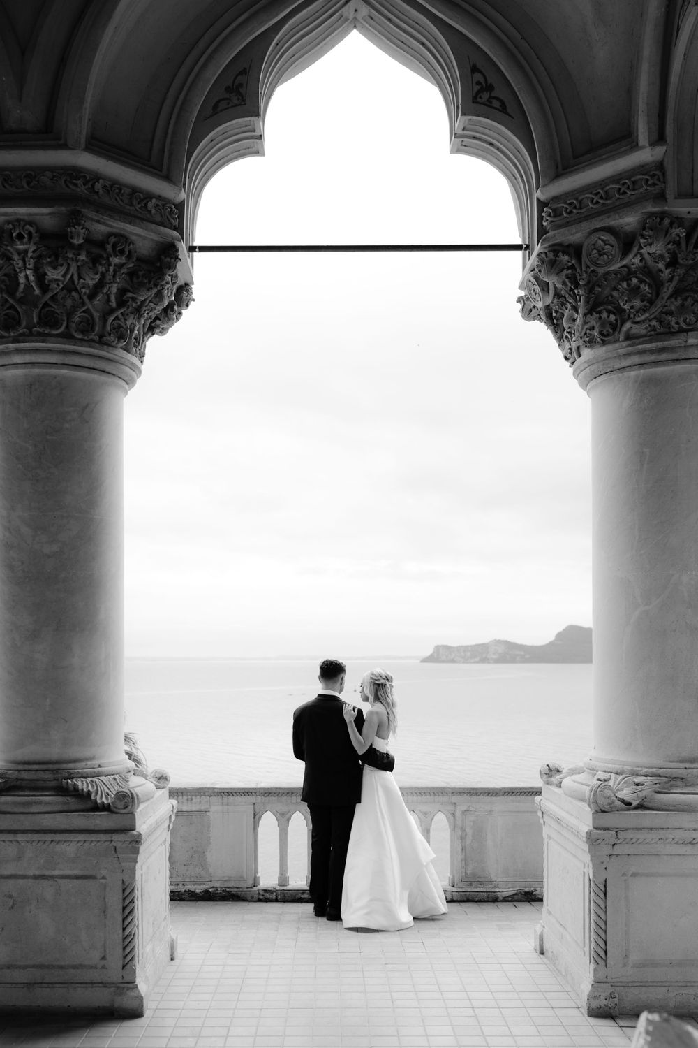 Stylish couple posing for an editorial photoshoot on Isola del Garda surrounded by lake