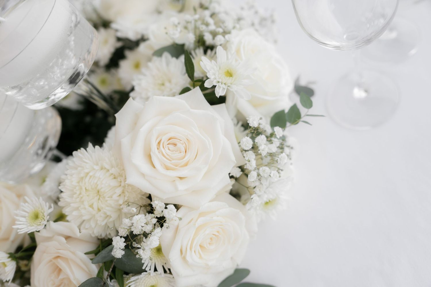 Elegant white rose bouquet with baby's breath and chrysanthemums, perfect for weddings or special occasions.
