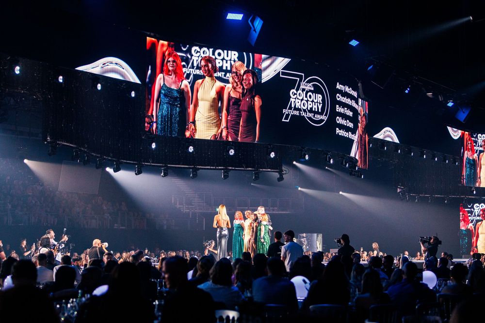 A glamorous awards ceremony stage with performers and a large screen displaying Colour Trophy 70th anniversary branding.