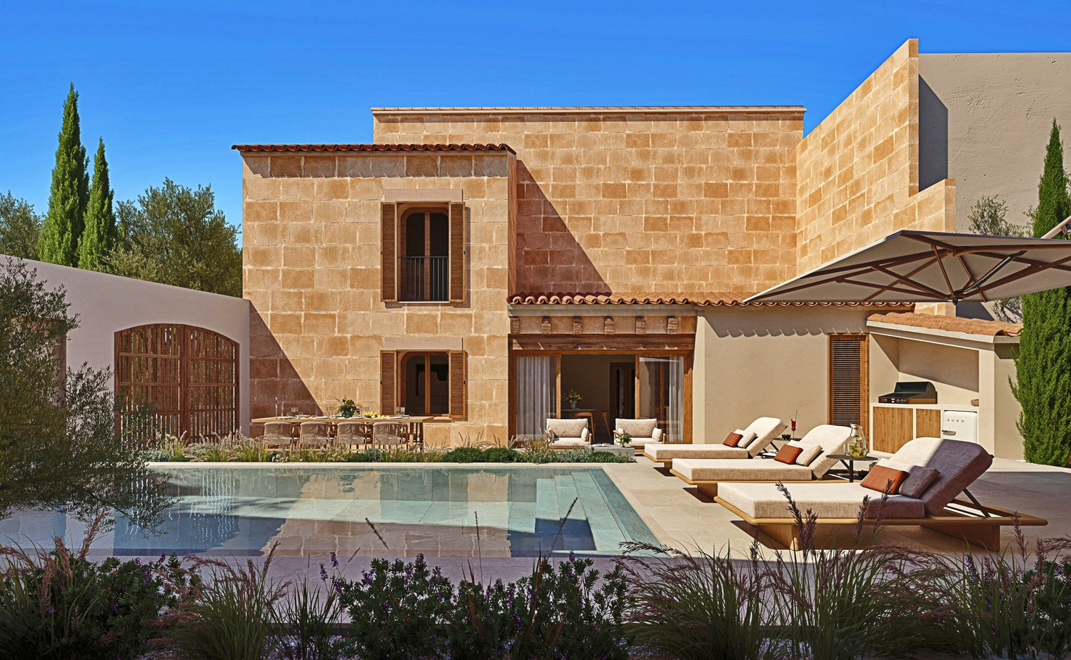 Historic Mediterranean courtyard with stone buildings and olive trees providing shade.