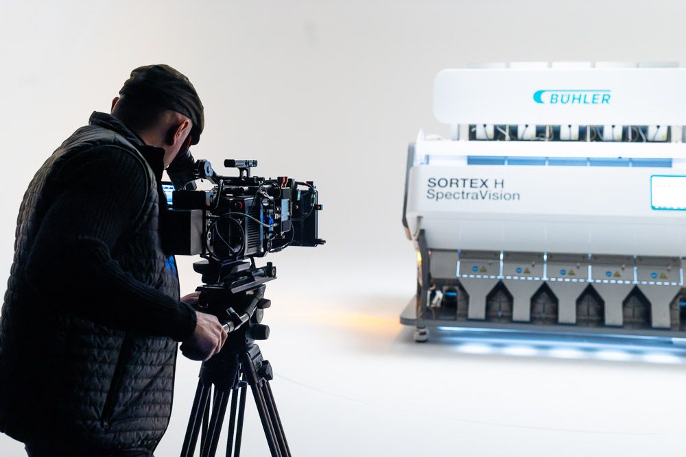 Industrial product photography | Cameraman with tripod focuses on Buhler food sorting machine in photographic studio
